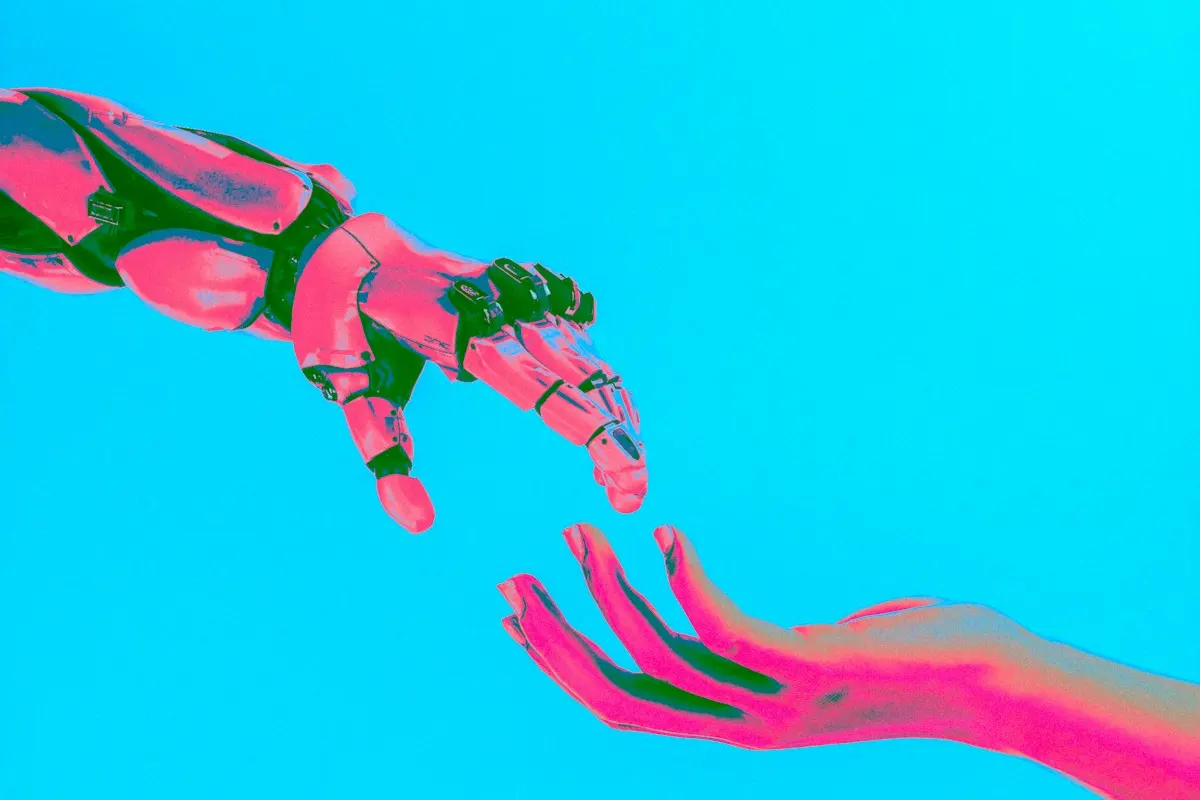 Mão robótica rosa e mão humana se aproximando sobre fundo ciano, ilustrando a colaboração entre pessoas e agentes de IA.