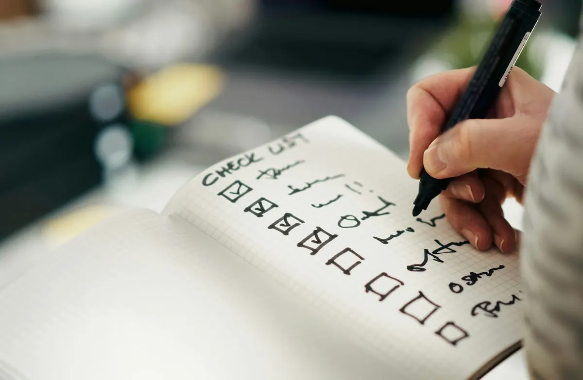 Auditoria Google Ads: mão marcando itens de um checklist em caderno.