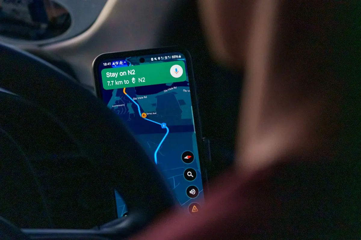Celular preso no painel de um carro mostrando um aplicativo de mapa com a rota traçada até o destino.