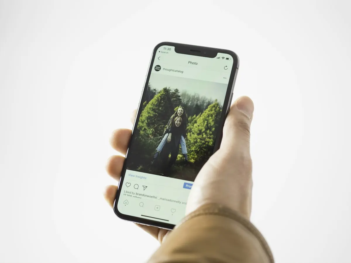 Mão segurando um smartphone, de onde sai a maior parte das buscas que mostram como o Google ganha dinheiro com o leilão.