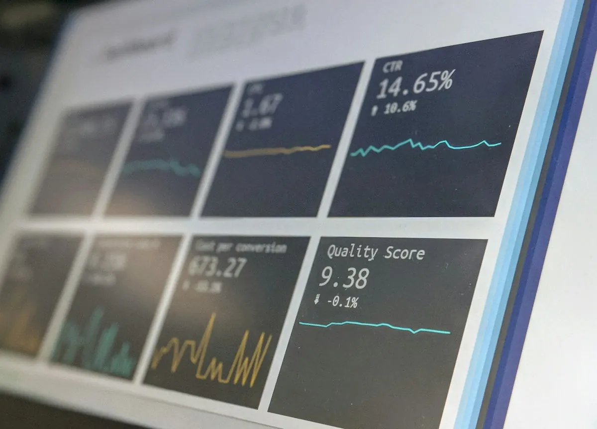 Monitores com painéis de dados e métricas, representando o histórico e o desempenho da conta de anúncios.