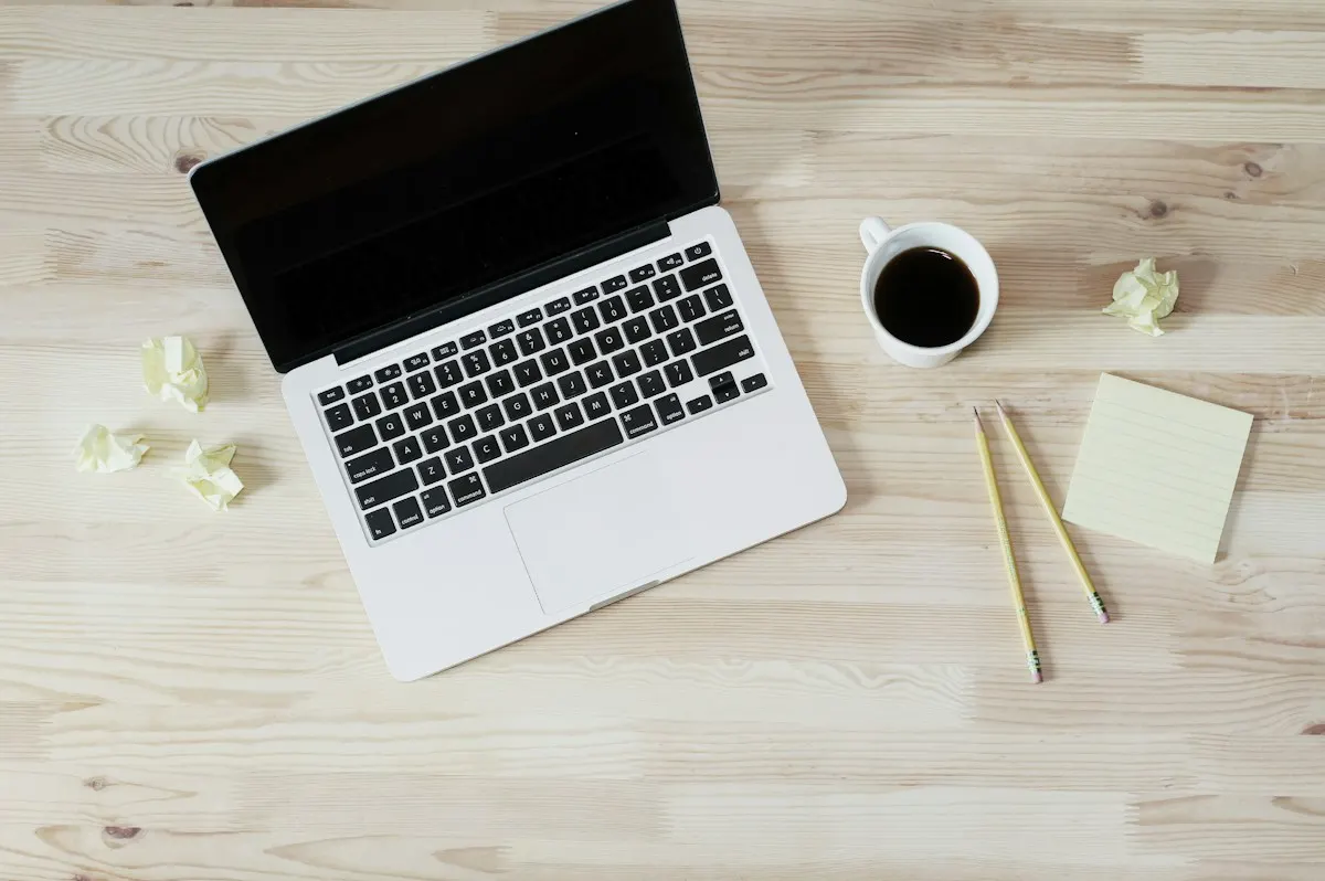 Notebook, xícara de café e notas adesivas sobre a mesa, representando o briefing e o planejamento antes de pedir o site à IA.
