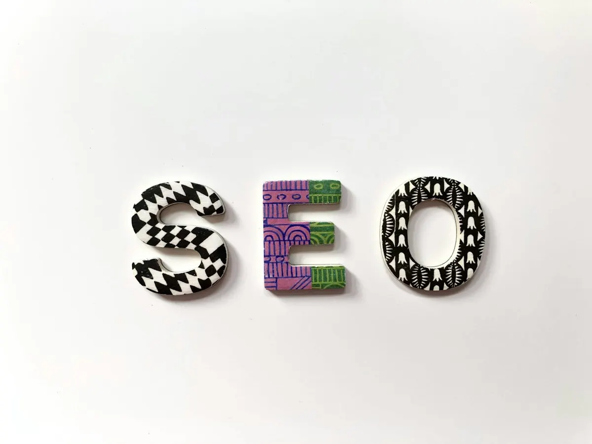 Letras S, E e O com padrões coloridos sobre fundo branco, símbolo do SEO para chegar à primeira página do Google.