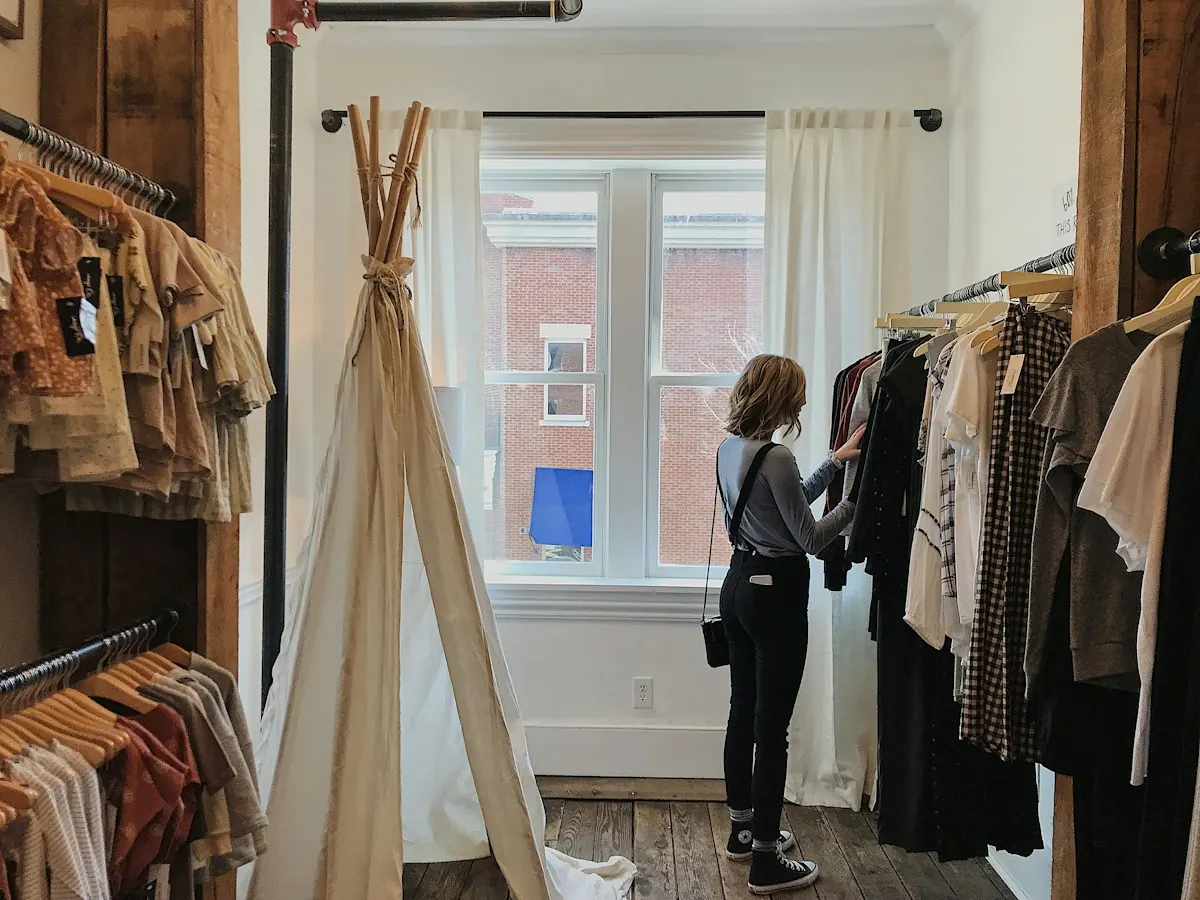 Cliente escolhendo roupas em uma loja, comparando opções antes de decidir, como no efeito isca.