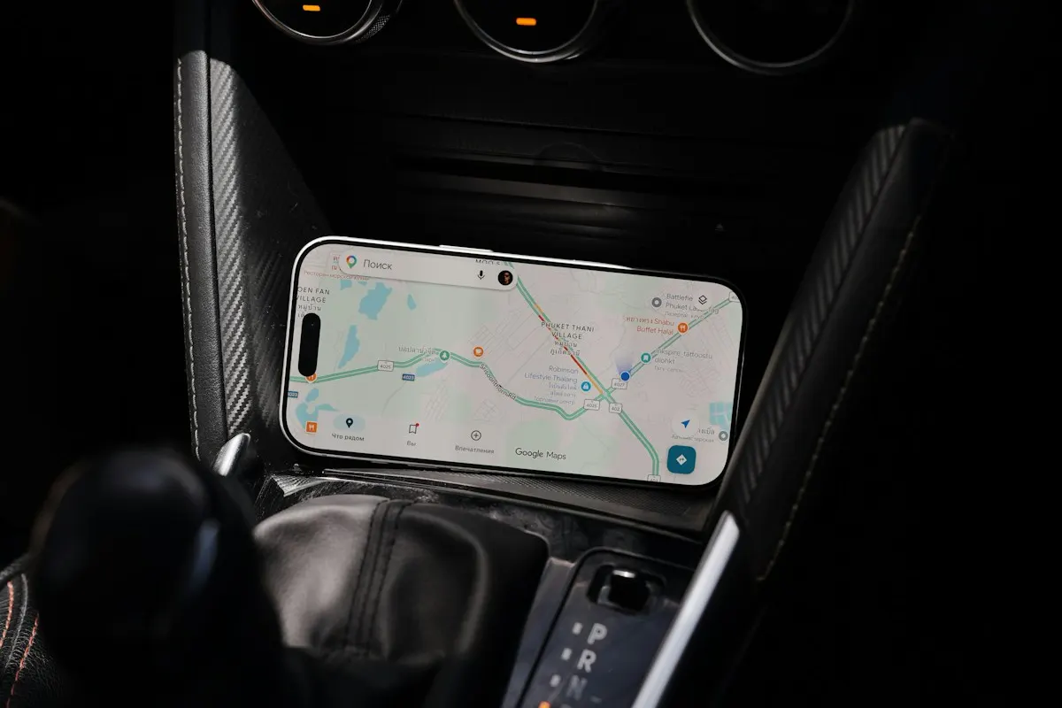 Smartphone preso no console de um carro mostrando um mapa digital com rota traçada, como quem procura um endereço no caminho.
