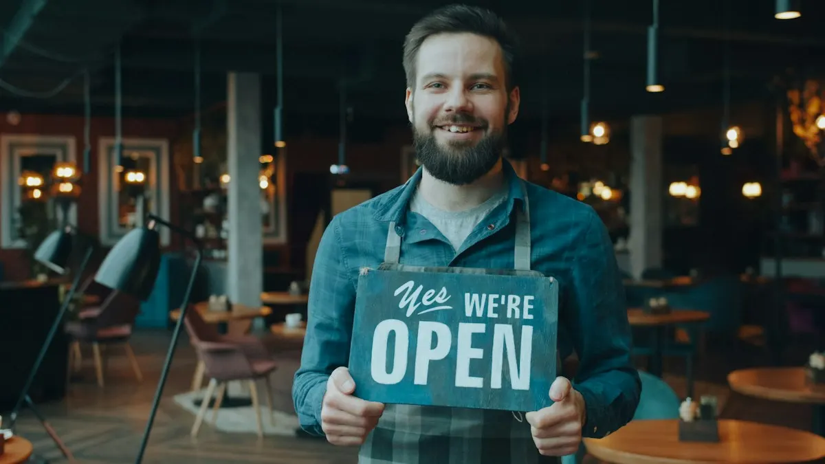 Dono de restaurante sorrindo e segurando uma placa com a palavra OPEN, indicando que o estabelecimento está aberto.