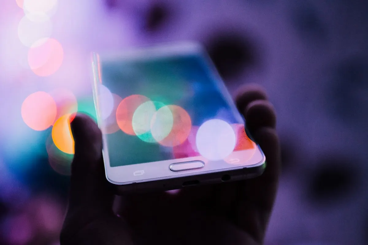 Pessoa segurando celular, onde a maioria dos cliques de anúncio chega à landing page.