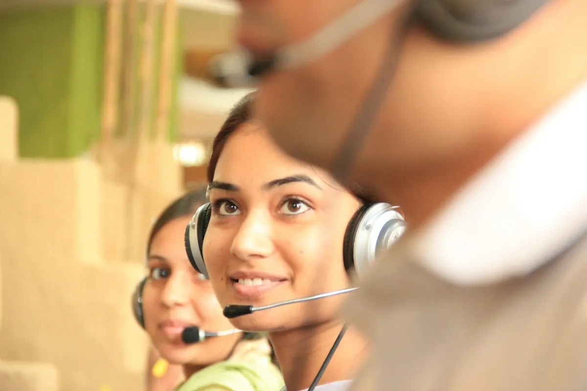 Atendentes com headset em uma central de atendimento, representando o contato rápido com os leads que chegam dos anúncios.