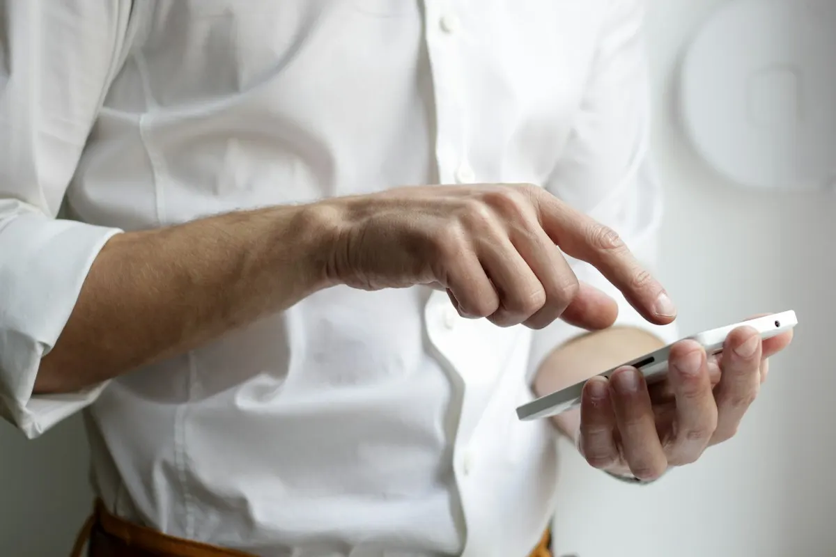 Pessoa segurando um smartphone, representando o preenchimento de um formulário instantâneo de anúncio no Facebook ou no Instagram.