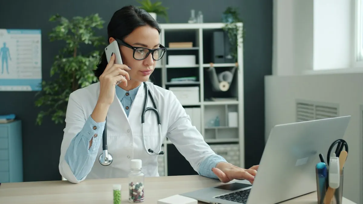 Médica de jaleco e óculos falando ao telefone enquanto usa o notebook na mesa do consultório.