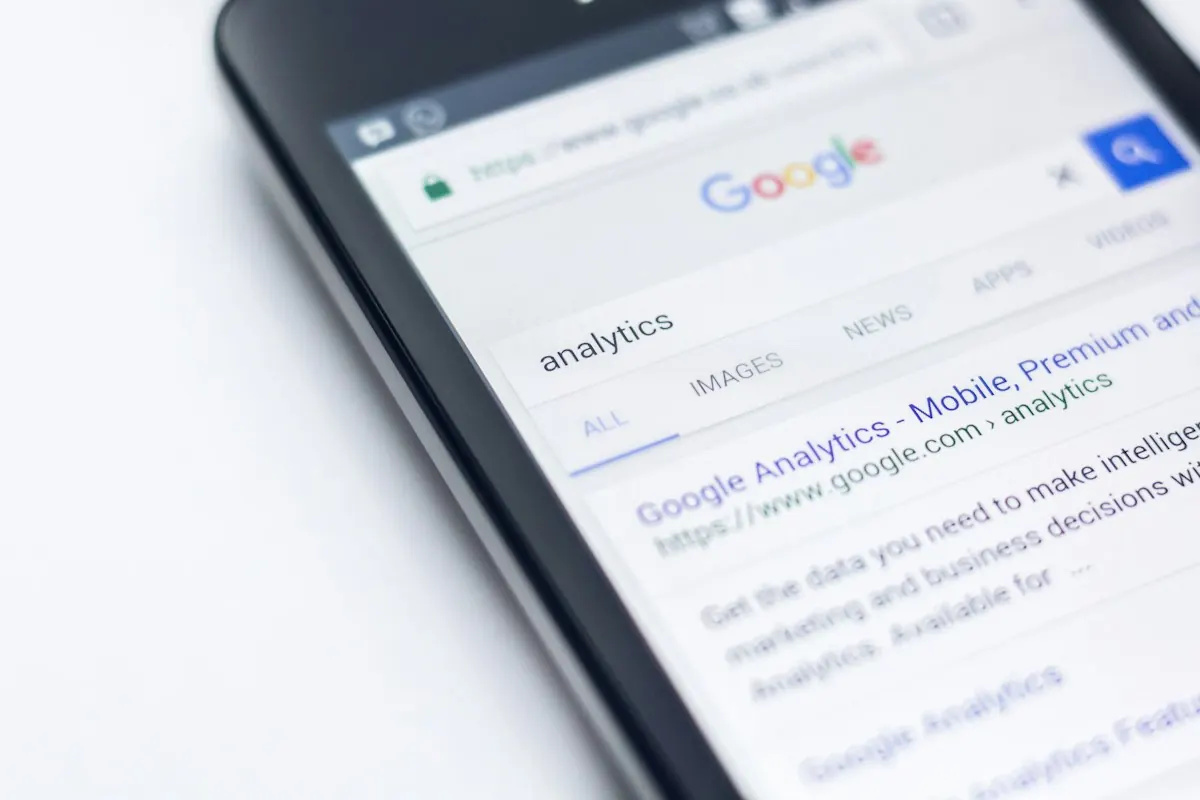 Celular sobre uma mesa branca mostrando uma página de resultados de busca do Google.