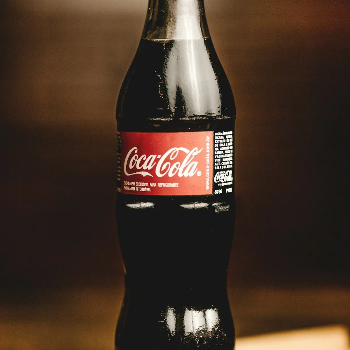 Garrafa de vidro de Coca-Cola sobre a mesa, embalagem que virou mídia na campanha de marketing viral Share a Coke.