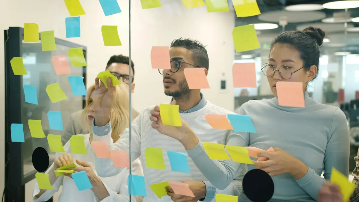 Equipe colando post-its coloridos numa parede de vidro durante uma reunião de ideias.