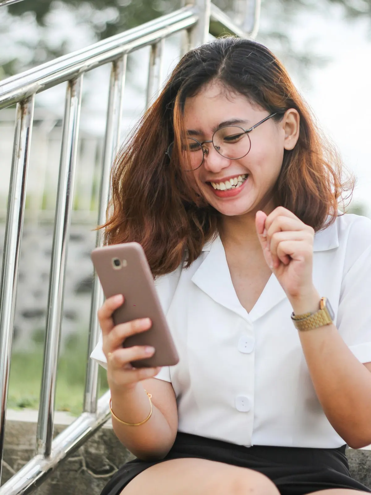 Mulher sorrindo enquanto conversa pelo celular, como o lead que recebe resposta logo depois de clicar no anúncio.
