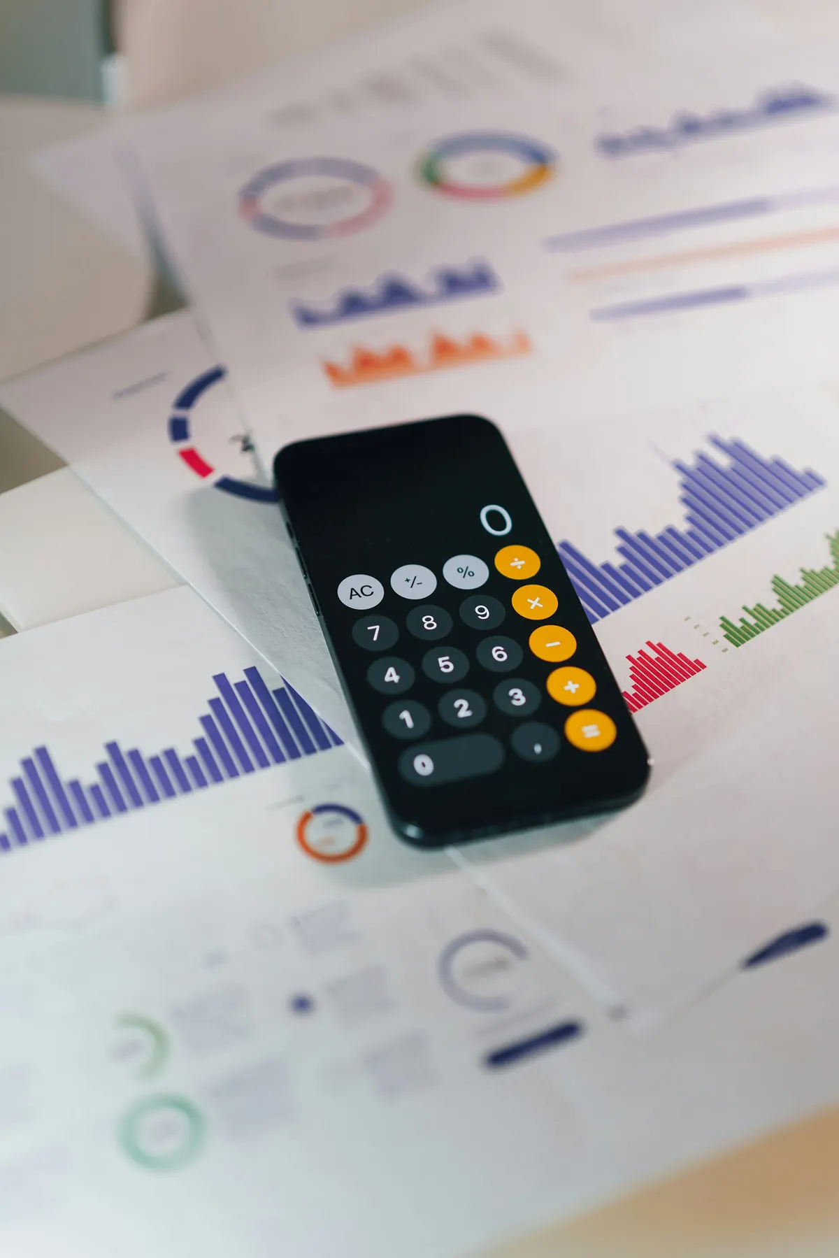 Celular com app de calculadora sobre relatórios financeiros, como quem estima verba de Google Ads antes de anunciar.