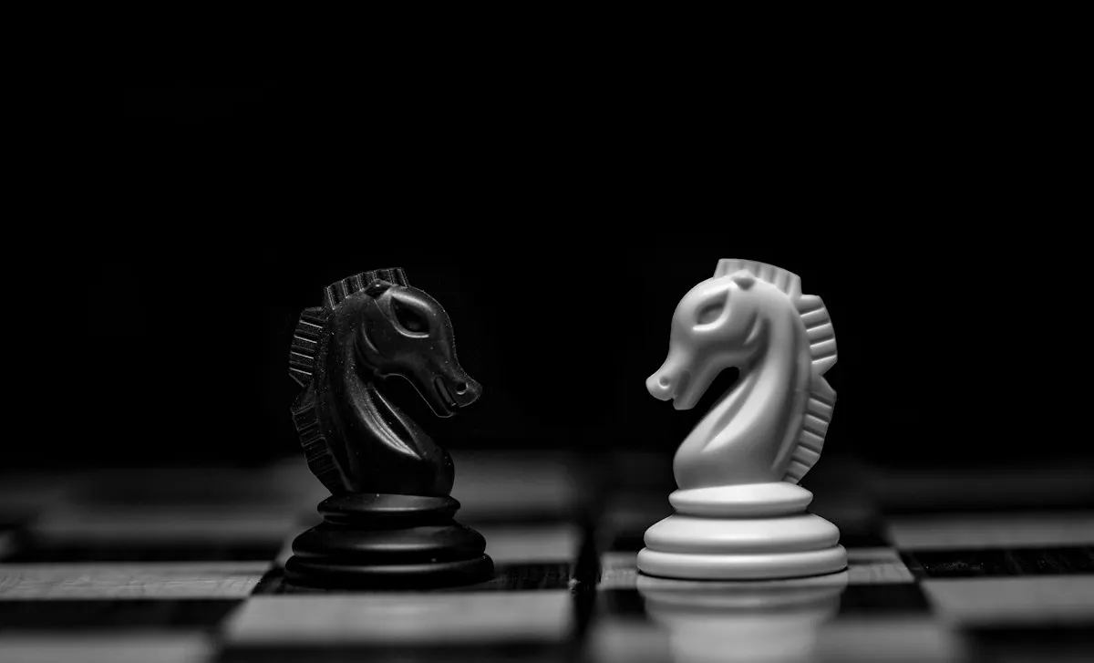 Dois cavalos de xadrez, um preto e um branco, frente a frente, como humano e máquina no jogo da imitação do Teste de Turing.