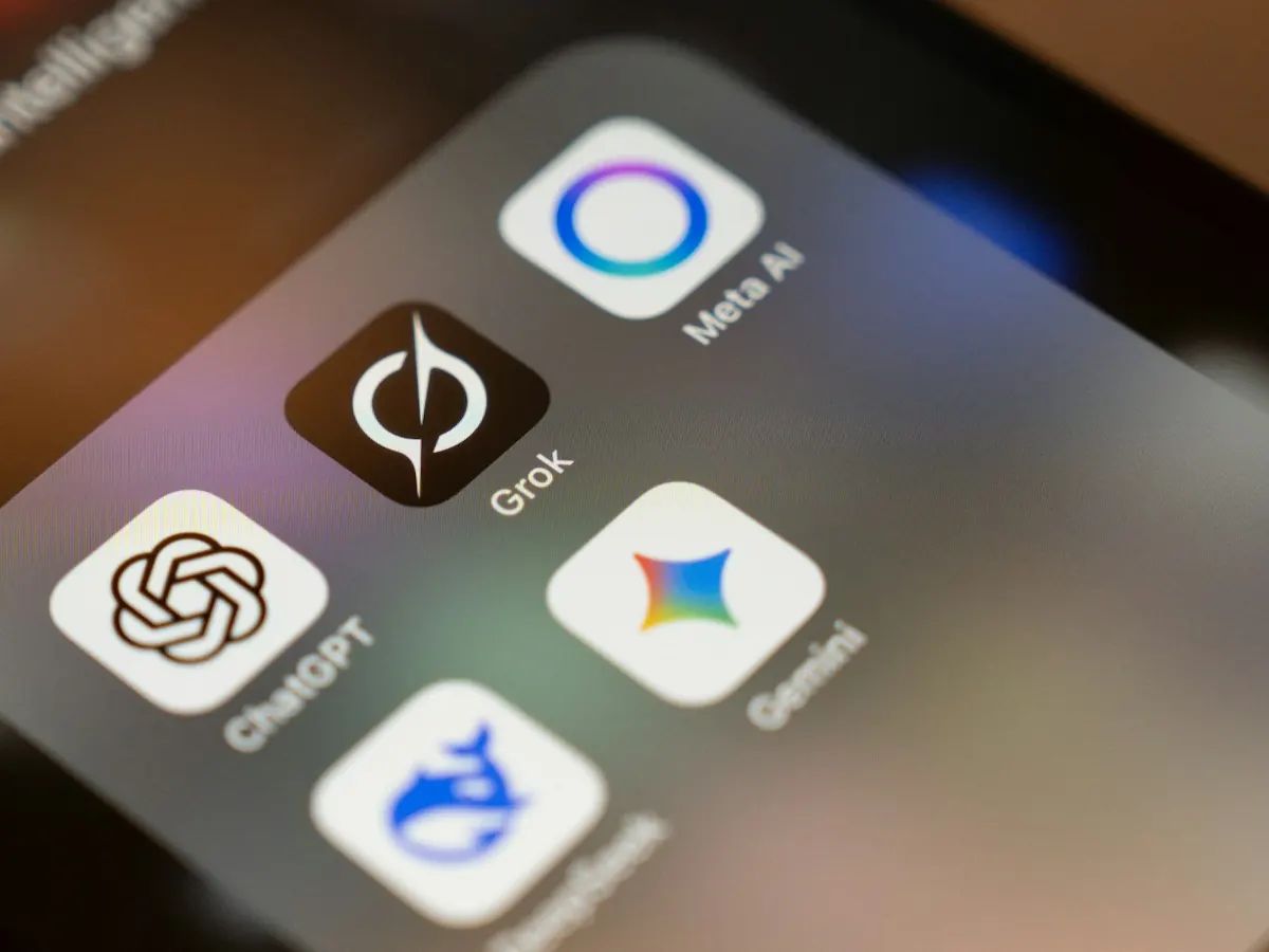 Tela de celular com os ícones dos aplicativos ChatGPT, Grok, Meta AI, Gemini e DeepSeek agrupados numa pasta.