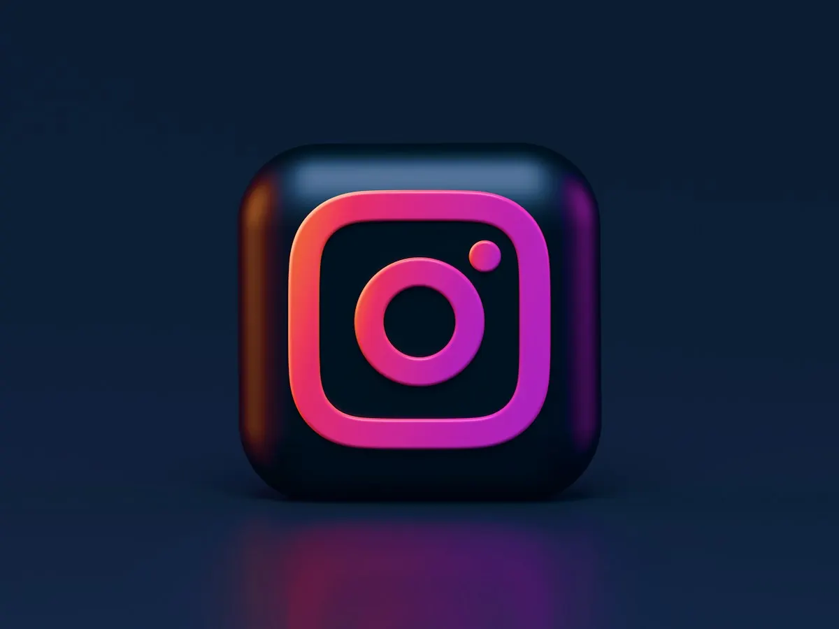 Ícone do Instagram em 3D, com contorno em degradê rosa e laranja, iluminado sobre um fundo azul-escuro.