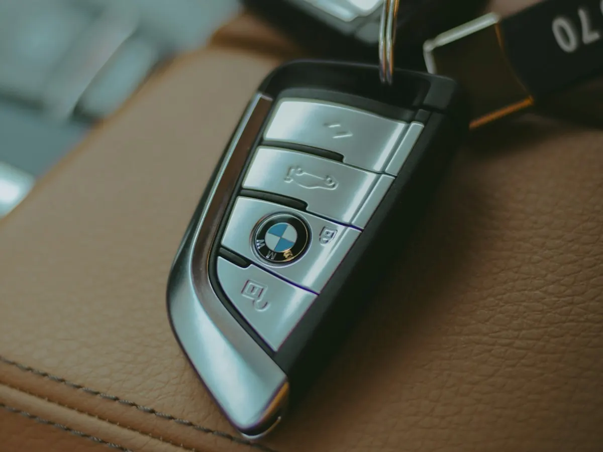 Chave de um carro de luxo apoiada sobre um banco de couro caramelo.