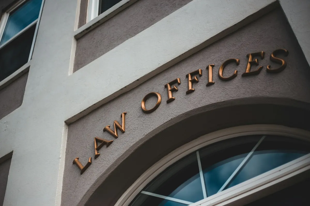 Fachada de prédio com a inscrição Law Offices, escritórios de advocacia, em letras douradas.
